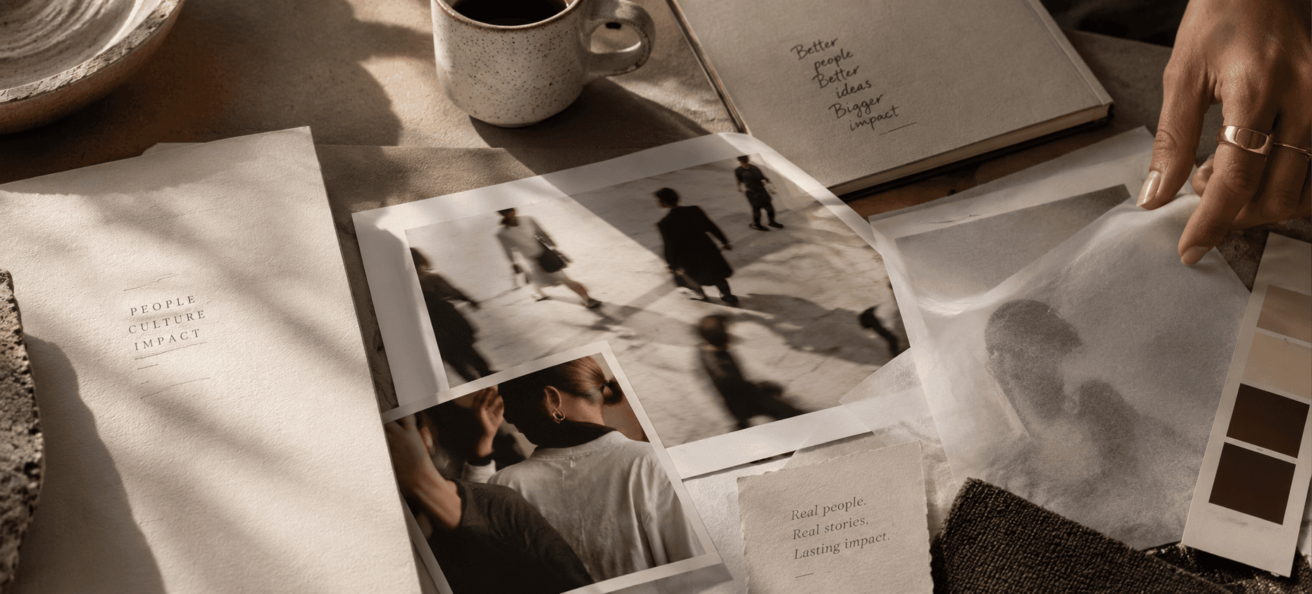 Hands sorting black-and-white photographs and notes across a table