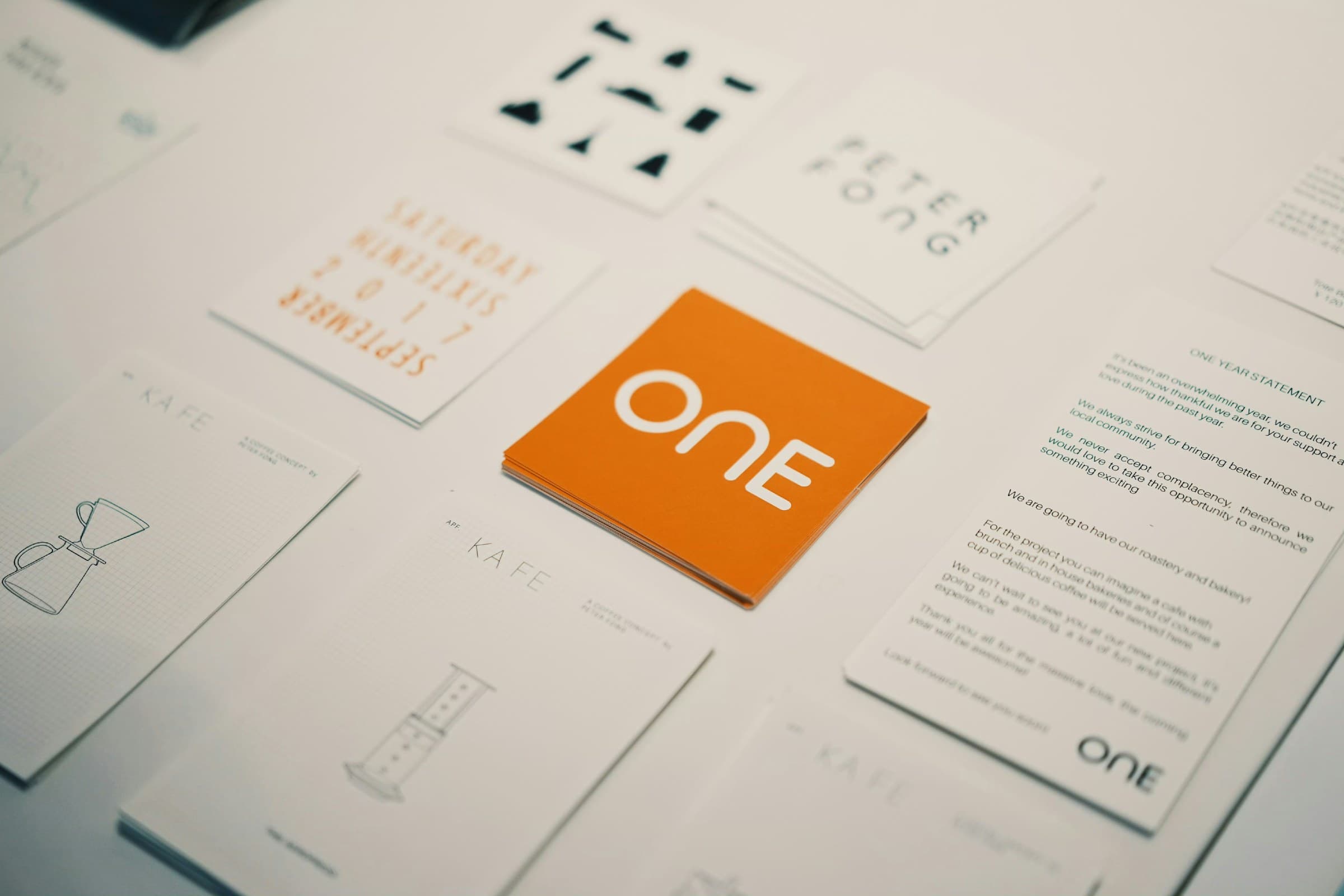A set of printed identity cards and stationery on white, with one orange card